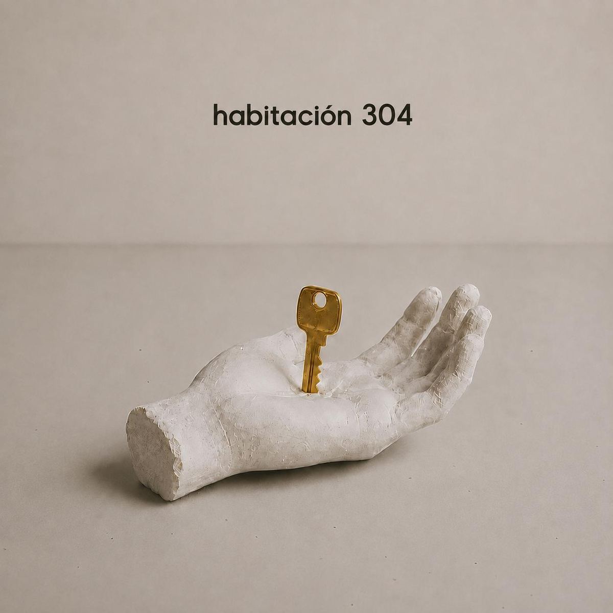 Portada de habitación 304: una mano de escayola sostiene una llave dorada